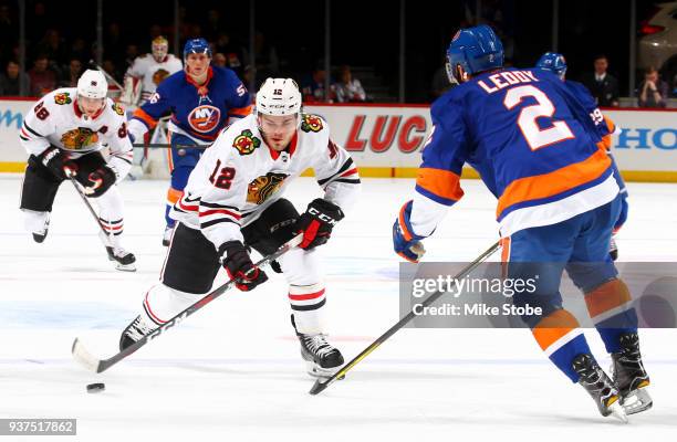 Nick Leddy of the New York Islanders defends against Alex DeBrincat of the Chicago Blackhawks as he gains the offensive blue line during the second...