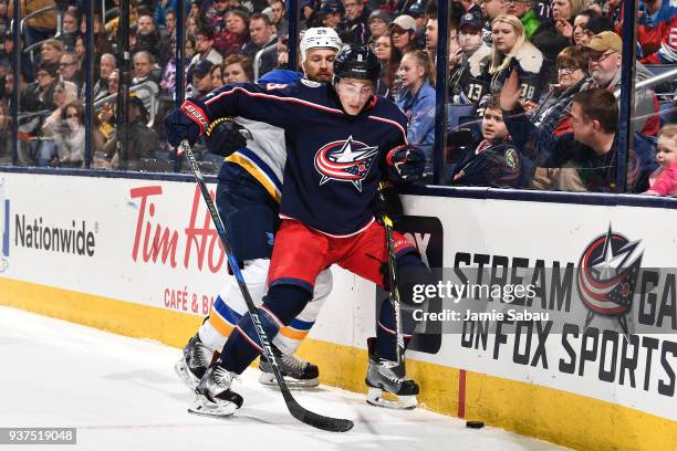 Zach Werenski of the Columbus Blue Jackets shields the puck from Kyle Brodziak of the St. Louis Blues during the second period of a game on March 24,...