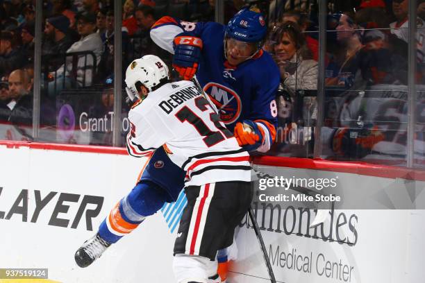 Alex DeBrincat of the Chicago Blackhawks checks Brandon Davidson of the New York Islanders during the second period at Barclays Center on March 24,...