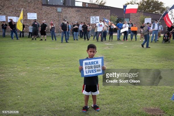McKinley Morris poses for his mother in front of a group of counter-demonstrators following a March for Our Lives rally on March 24, 2018 in Killeen,...