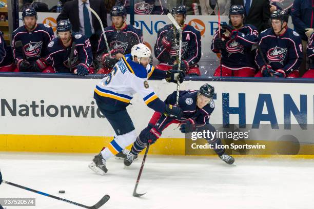 St. Louis Blues defenseman Joel Edmundson checks Columbus Blue Jackets left wing Matt Calvert as he reaches for the puck in the second period of a...