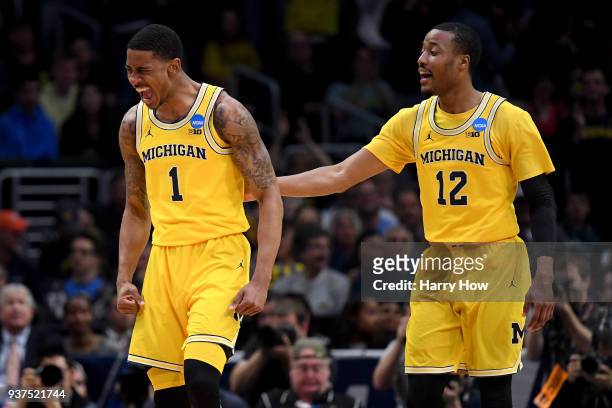 Charles Matthews and Muhammad-Ali Abdur-Rahkman of the Michigan Wolverines react after Matthews dunks the ball in the first half against the Florida...