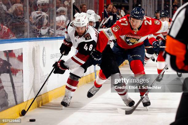 Jordan Martinook of the Arizona Coyotes skates along the boards against Nick Bjugstad of the Florida Panthers at the BB&T Center on March 24, 2018 in...