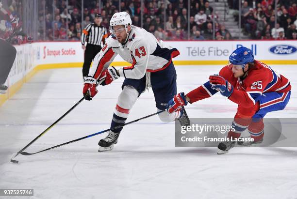 Tom Wilson of the Washington Capitals skates with the puck under pressure from Jacob De La Rose of the Montreal Canadiens in the NHL game at the Bell...