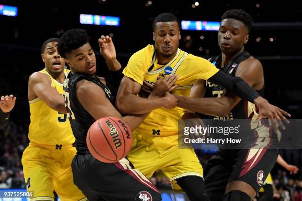 Muhammad-Ali Abdur-Rahkman of the Michigan Wolverines goes after the ball between M.J. Walker and Mfiondu Kabengele of the Florida State Seminoles in...