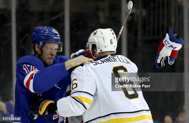 Peter Holland of the New York Rangers and Marco Scandella of the Buffalo Sabres get into a fist fight in the second period during their game at...