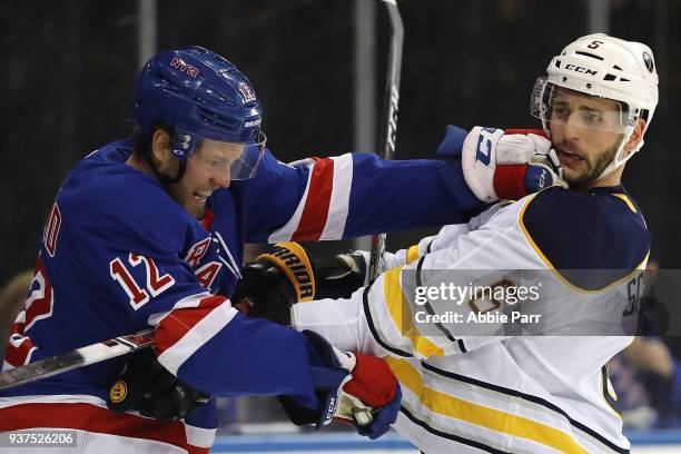 Peter Holland of the New York Rangers and Marco Scandella of the Buffalo Sabres get into a fist fight in the second period during their game at...