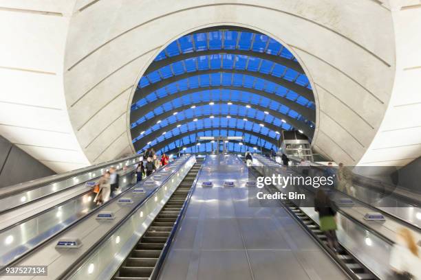 commuters on escalators descending into subway station, london, england - canary wharf railway station stock pictures, royalty-free photos & images