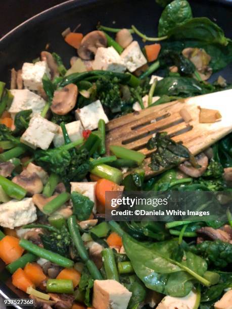 stir frying vegetables in a wok - stir frying european stock pictures, royalty-free photos & images