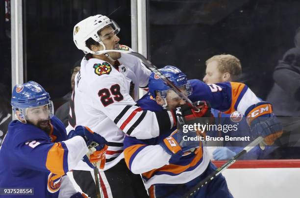 Andreas Martinsen of the Chicago Blackhawks hangs on to Johnny Boychuk of the New York Islanders during the third period at the Barclays Center on...