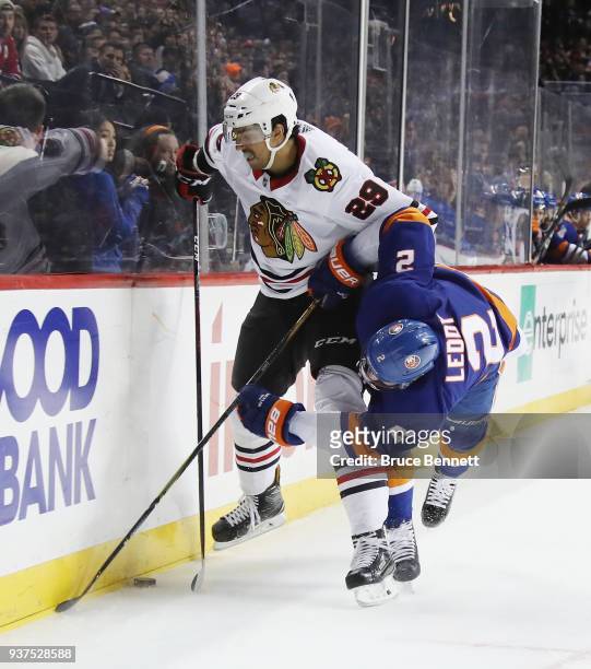 Andreas Martinsen of the Chicago Blackhawks brushes aside Nick Leddy of the New York Islanders during the second period at the Barclays Center on...