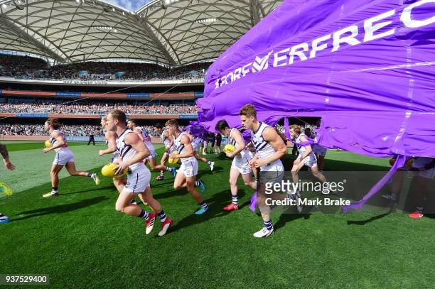 Freemantle run through their banner during the round one AFL match between the Port Adelaide Power and the Fremantle Dockers at Adelaide Oval on...