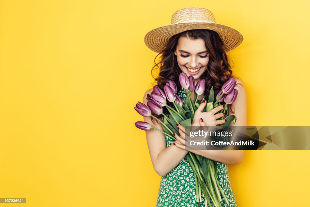 Lovely woman with purple tulips bunch