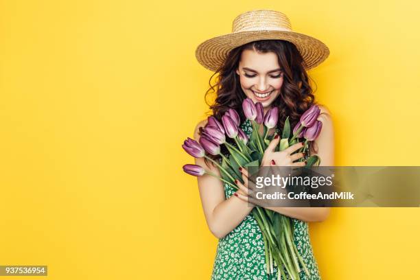 mulher adorável com monte de tulipas roxas - yellow dress - fotografias e filmes do acervo