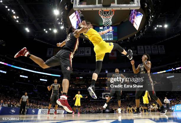 Moritz Wagner of the Michigan Wolverines is fouled by CJ Walker of the Florida State Seminoles in the first half in the 2018 NCAA Men's Basketball...