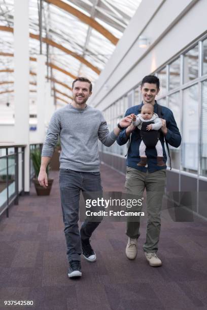 two dads take their infant daughter to the mall - surrogacy stock pictures, royalty-free photos & images