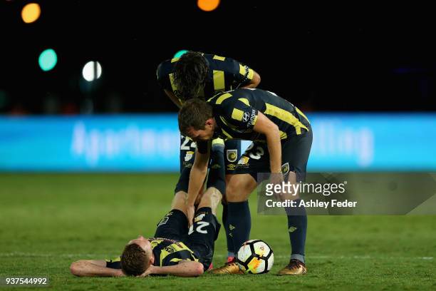 Kye Rowles of the Mariners is attended to by Wout Brama and Lachlan Wales during the round 24 A-League match between the Central Coast Mariners and...