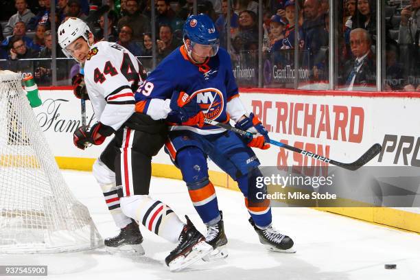 Brock Nelson of the New York Islanders and Jan Rutta of the Chicago Blackhawks battle for the puck at Barclays Center on March 24, 2018 in New York...