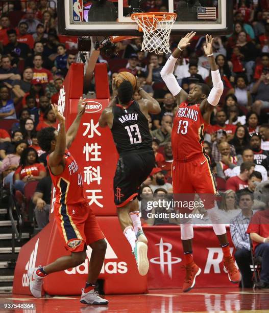 James Harden of the Houston Rockets drives between Cheick Diallo of the New Orleans Pelicans and Solomon Hill at Toyota Center on March 24, 2018 in...