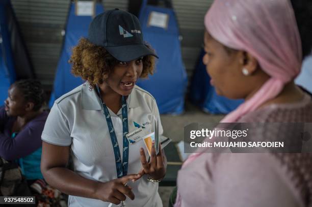 Students from the University of the Witwatersrand explain the self HIV testing kit, in Hillbrow, Johannesburg, on March 19, 2018. Self-testing kits...