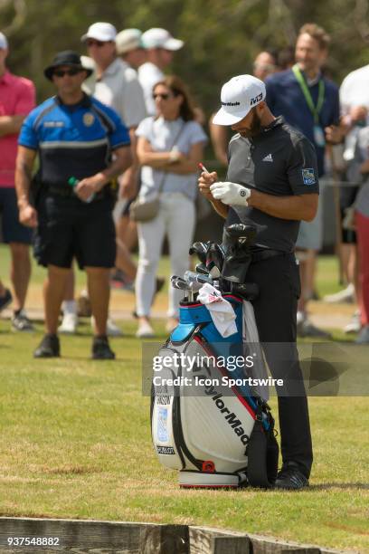 Dustin Johnson marks a new ball after hitting into the water on the thirteenth hole during the WGC-Dell Technologies Match Play Tournament on March...