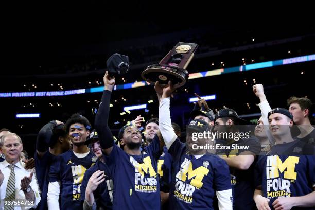The Michigan Wolverines celebrate with the West Regional trophy after their 58-54 victory against the Florida State Seminoles in the 2018 NCAA Men's...