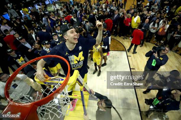 Duncan Robinson of the Michigan Wolverines cuts down the net after the Wolverines 58-54 victory against the Florida State Seminoles in the 2018 NCAA...