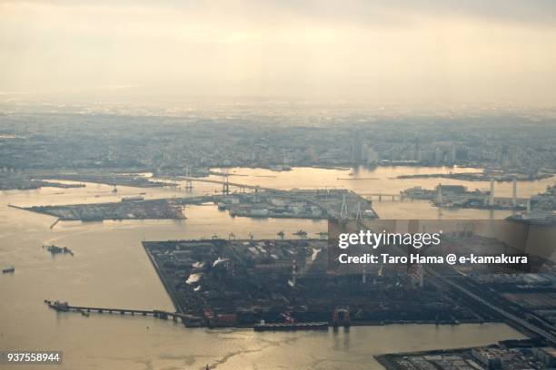 tokyo bay, yokohama bay bridge, yokohama harbor, yokohama minatomirai area and factory area in yokohama city in kanagawa prefecture in japan sunset time aerial view from airplane - yokohama brücke stock-fotos und bilder