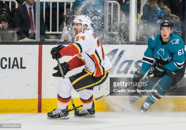 Calgary Flames Defenceman Travis Hamonic moves the puck behind the Calgary net during the game between the Calgary Flames and the San Jose Sharks on...