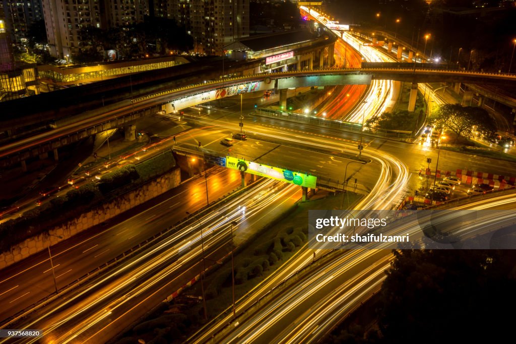 Long exposure of traffic on Federal Highway over rainy sunset in Kuala Lumpur, Malaysia.