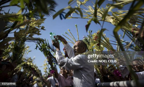 Layman of the Roman Catholic Church blesses palms during Palm Sunday celebrations at the Our Lady of Lourdes Grotto church in Bulacan, north of...