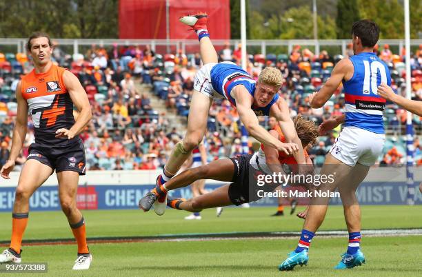 Tim English of the Bulldogs and Lachie Whitfield of the Giants contest possession during the round one AFL match between the Greater Western Sydney...