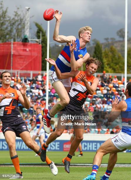 Tim English of the Bulldogs and Lachie Whitfield of the Giants contest possession during the round one AFL match between the Greater Western Sydney...