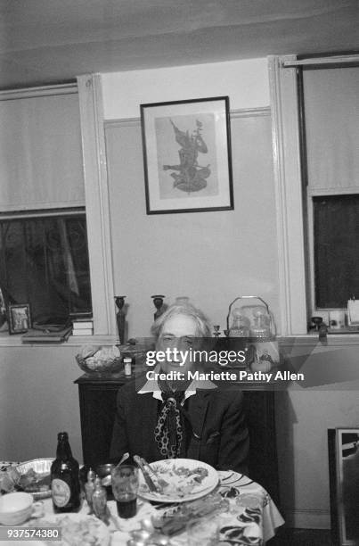 New York, New York, USA - 1980s: English author Quentin Crisp wears his signature scarf and sits at a dinner table in "Transy House" in Brooklyn, New...