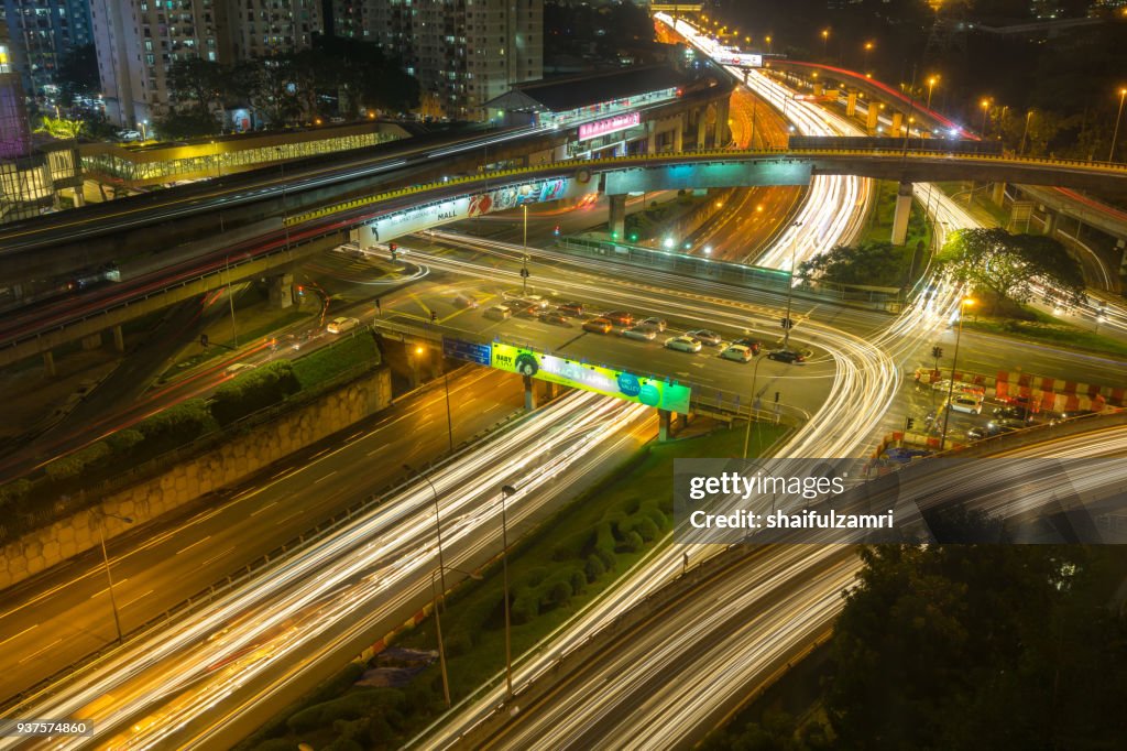 Long exposure of traffic on Federal Highway over rainy sunset in Kuala Lumpur, Malaysia.