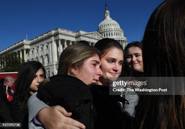 Students from Cypress Bay High School located in Weston, FL, Leah Lipke left, and Ashley Keene center, embrace as they gather with fellow Florida...