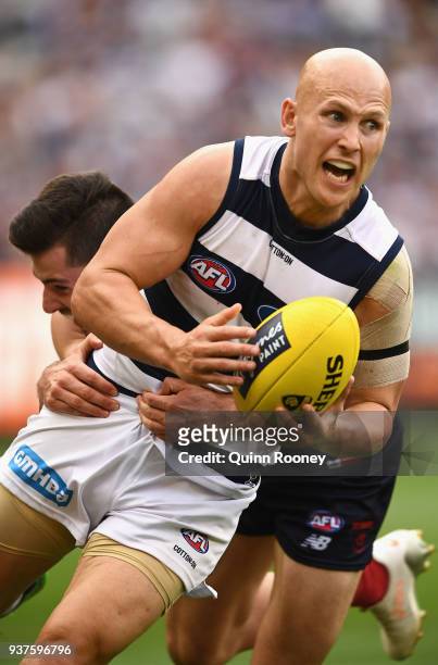 Gary Ablett of the Cats handballs whilst being tackled during the round one AFL match between the Melbourne Demons and the Geelong Cats at Melbourne...