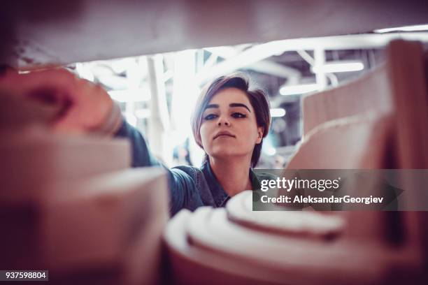 young female carpenter arrange the wooden chair sample parts on shelf - out of reach stock pictures, royalty-free photos & images