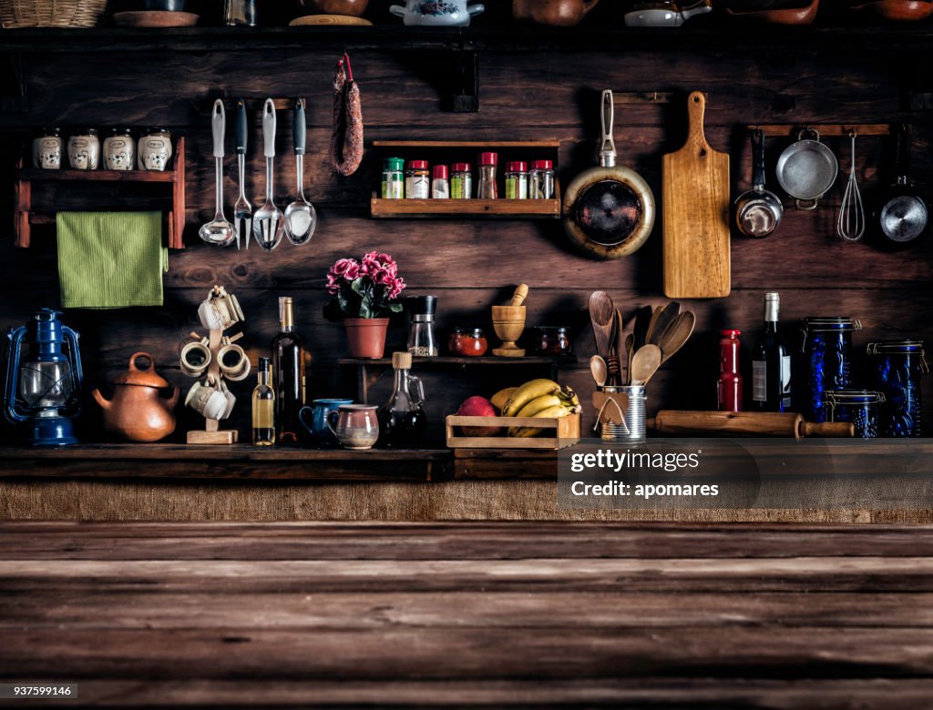 Tatsächliche rustikale Küche mit Utensilien zum Kochen. Tisch im Vordergrund mit Textfreiraum