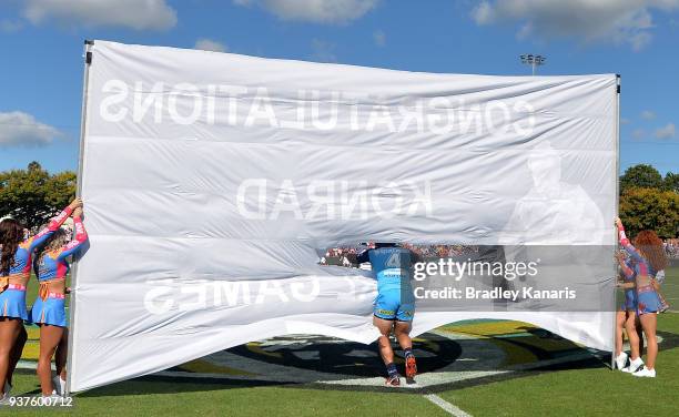 Konrad Hurrell of the Titans runs through the banner for his 100th game during the round three NRL match between the Gold Coast Titans and the St...