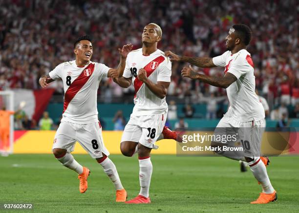 Andre Carrillo of Peru celebrates with teammates Christian Cueva and Jefferson Farfan after scoring the first goal of his team during the...