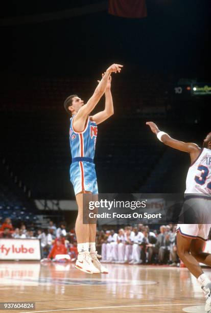 Drazen Petrovic of the New Jersey Nets shoots over Byron Irvin of the Washington Bullets during an NBA basketball game circa 1991 at the Capital...