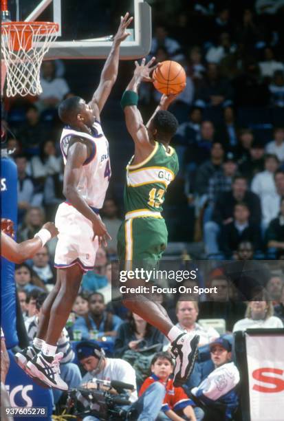 Kendall Gill of the Seattle Supersonics looks to get his shot off over Calbert Cheaney of the Washington Bullets during an NBA basketball game circa...