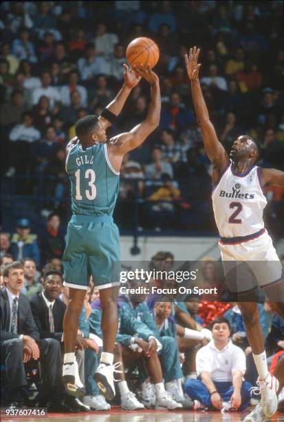 Kendall Gill of the Charlotte Hornets shoots over Buck Johnson of the Washington Bullets during an NBA basketball game circa 1993 at the Capital...