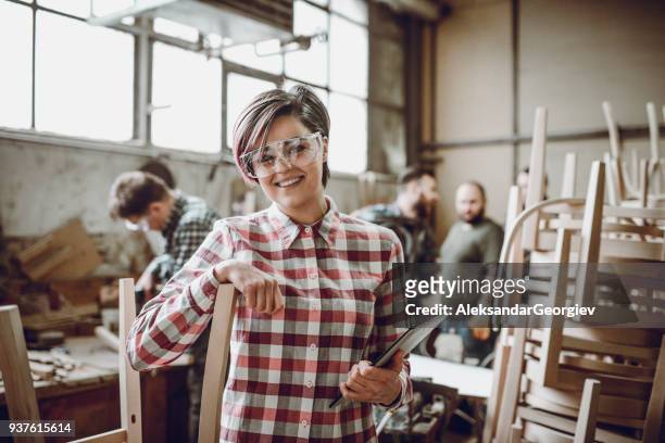 young lächelnd tischler in front of arbeiten team in ihrer werkstatt - schreiner tablet stock-fotos und bilder