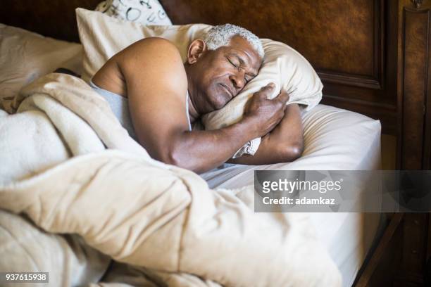 homem negro sênior, dormindo e acordando - black man sleeping in bed - fotografias e filmes do acervo