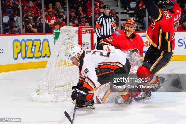 Chris Kelly of the Anaheim Ducks squeezes between Goalie David Rittich and Travis Hamonic of the Calgary Flames in an NHL game on March 21, 2018 at...