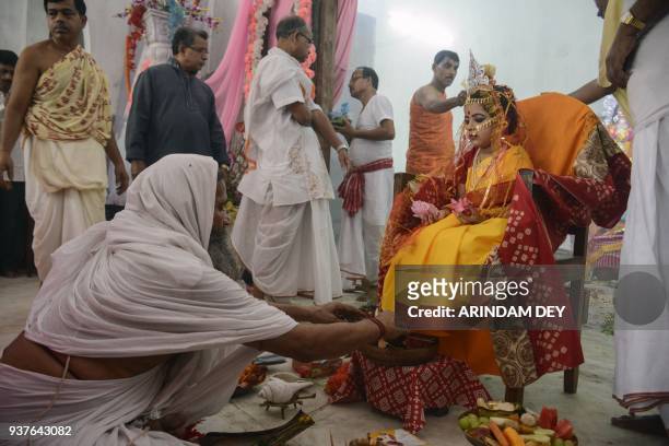 Hindu priest offers prayers to Indian girl Ananya Bhattacharya dressed as a Kumari, or "living goddess," at an event for the Hindu Navratri festival...