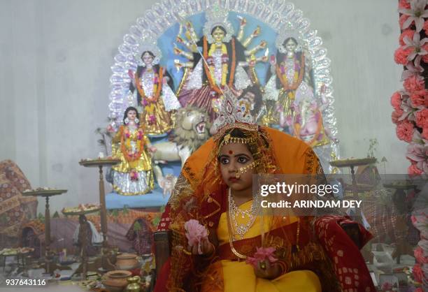 Indian girl Ananya Bhattacharya dressed as a Kumari, or "living goddess," takes part in an event for the Hindu Navratri festival at a temple in...