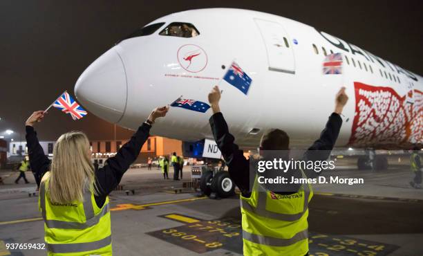 Qantas staff wave Australian and British flags at the Boeing 787 Dreamliner after landing at Heathrow Airport on March 25, 2018 in London, United...